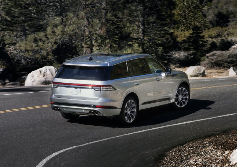 A 2023 Lincoln Aviator® Grand Touring model is shown being driven on a tight turn of a mountain road | Mark McLarty Lincoln in North Little Rock AR