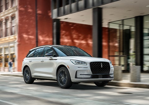 The 2024 Lincoln Corsair® SUV with the Jet Appearance Package and a Pristine White exterior is parked on a city street. | Mark McLarty Lincoln in North Little Rock AR