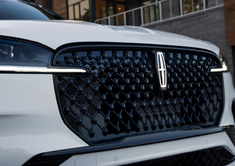 The black grille of a white 2025 Lincoln Aviator® SUV is shown with its fog lights on. | Mark McLarty Lincoln in North Little Rock AR