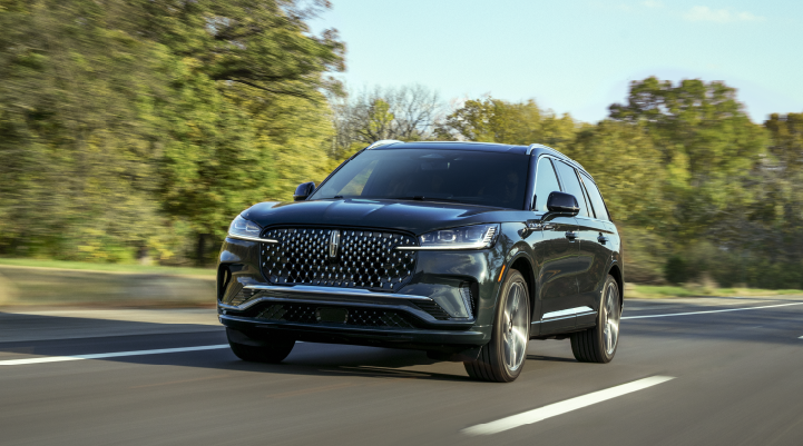 A 2025 Lincoln Black Label Aviator® SUV is being driven down a road lined with trees. | Mark McLarty Lincoln in North Little Rock AR