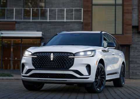 A 2026 Lincoln Aviator® Reserve model is shown with the available Jet Appearance Package parked near a restaurant. | Mark McLarty Lincoln in North Little Rock AR
