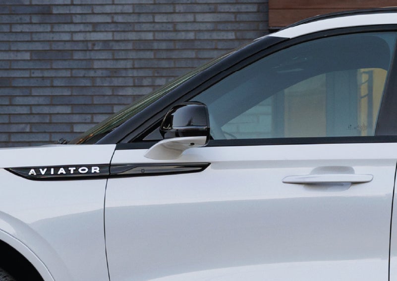 The driver’s side door and fender badging of a white 2026 Lincoln Aviator® SUV are showcased. | Mark McLarty Lincoln in North Little Rock AR