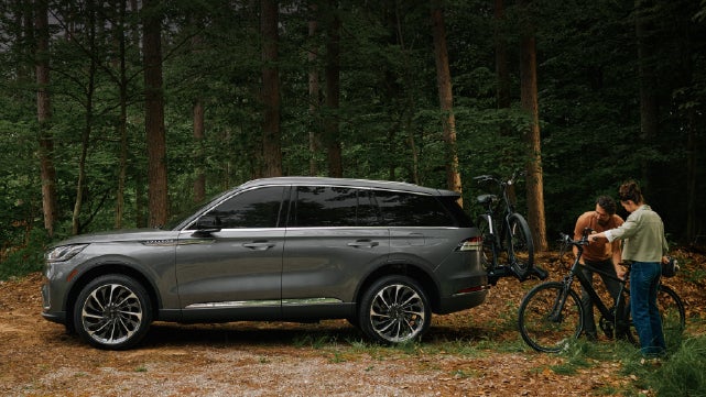 A father and son load e-bikes on a bike rack attached to a 2027 Lincoln Aviator® SUV. | McLarty Lincoln in North Little Rock AR