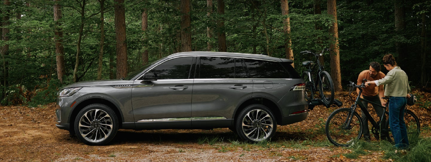 A father and son load e-bikes on a bike rack attached to a 2027 Lincoln Aviator® SUV. | McLarty Lincoln in North Little Rock AR